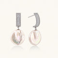 Rhodium-plated silver curved stud with pave stones and baroque pearl drop on white background