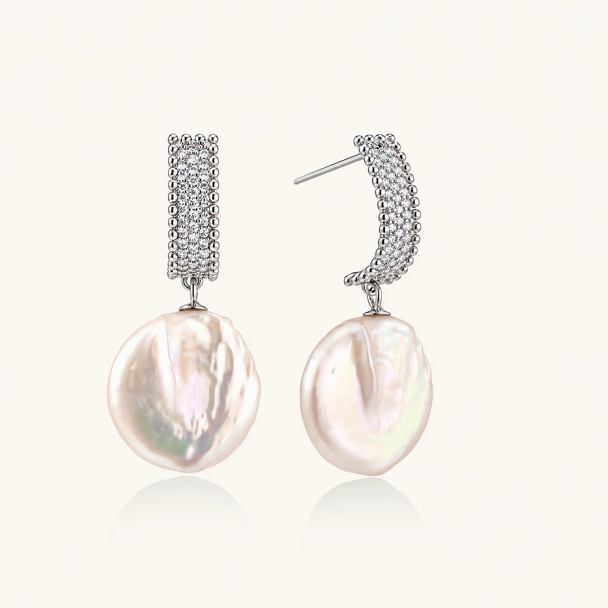 Rhodium-plated silver curved stud with pave stones and baroque pearl drop on white background