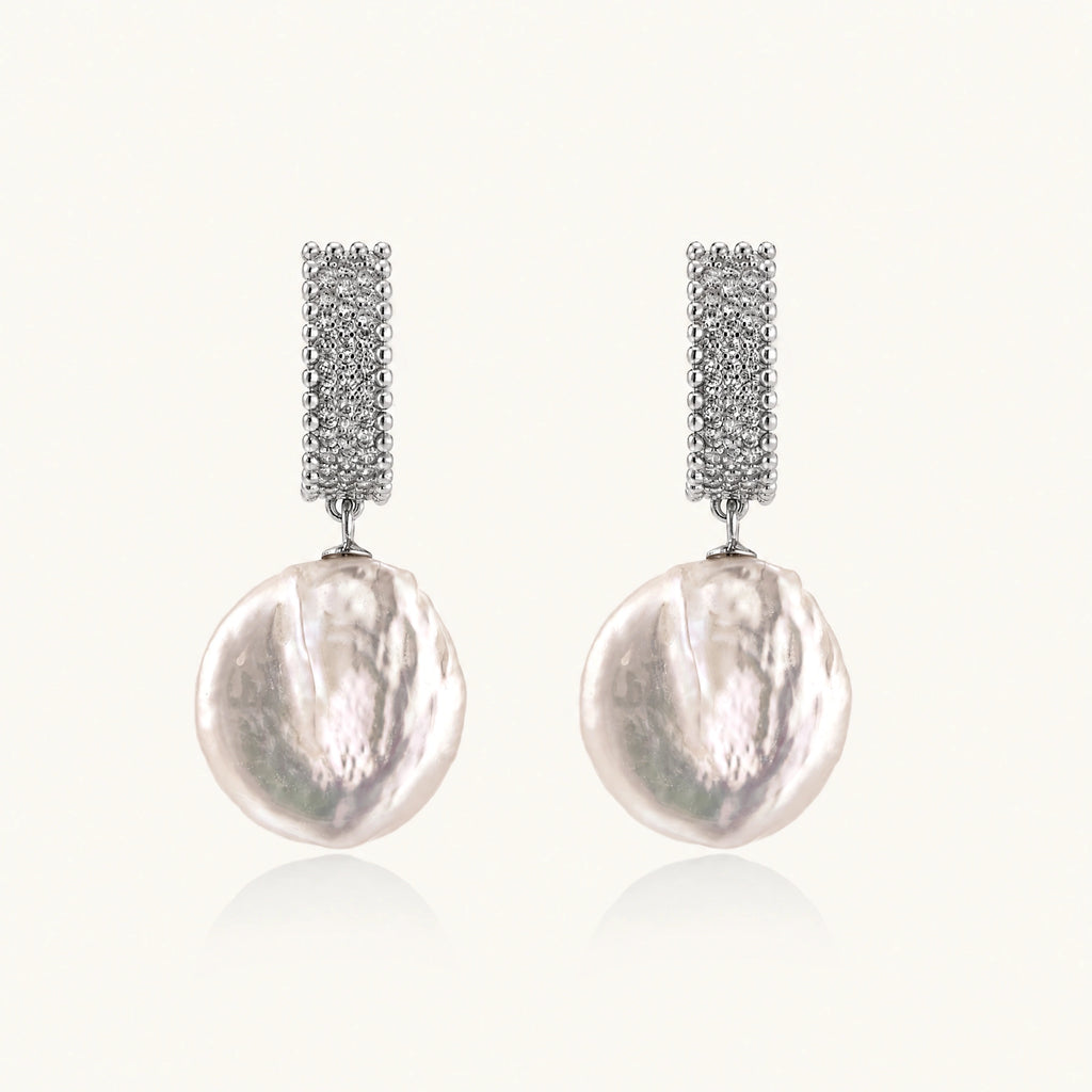 Rhodium-plated silver curved stud with pave stones and baroque pearl drop on white background