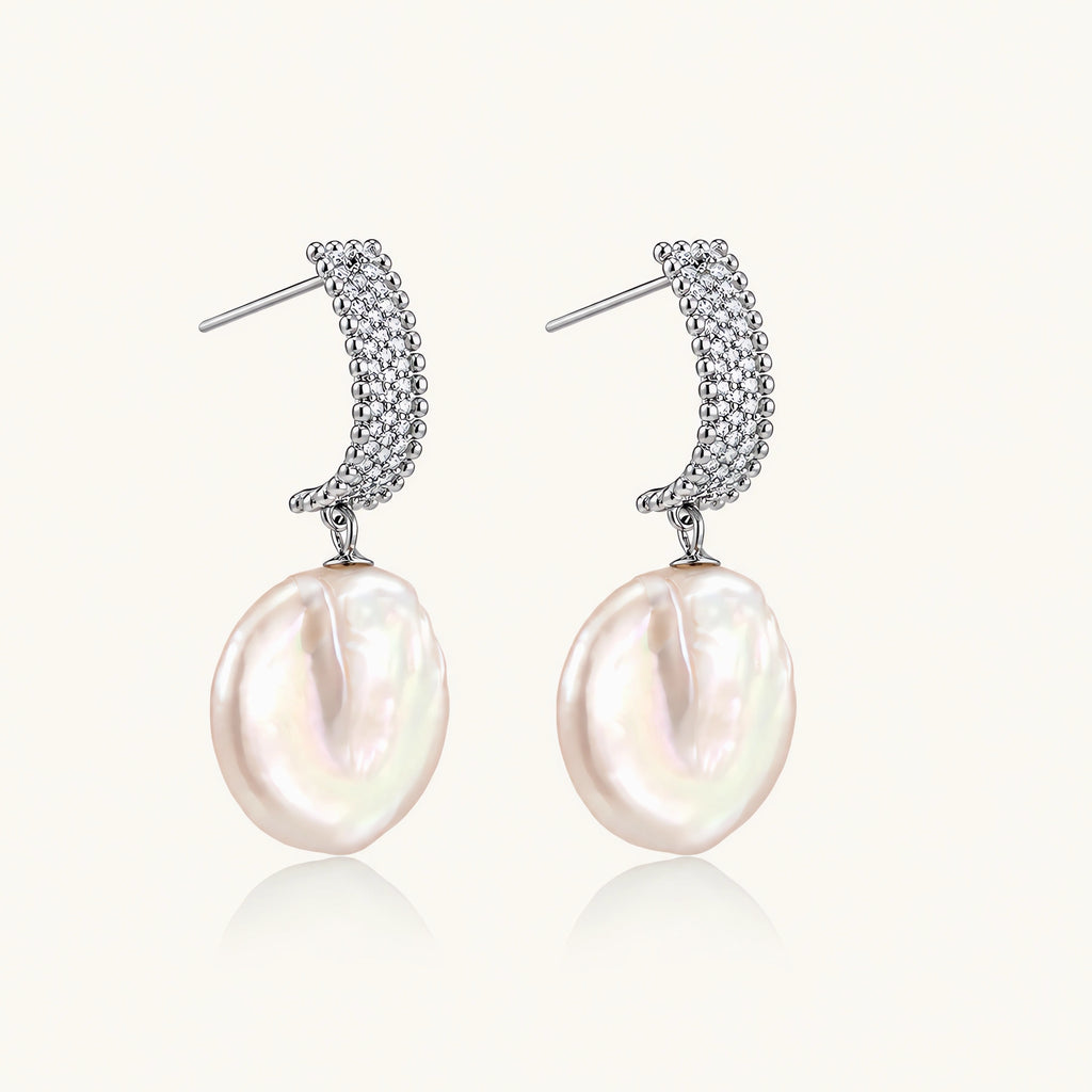 Rhodium-plated silver curved stud with pave stones and baroque pearl drop on white background