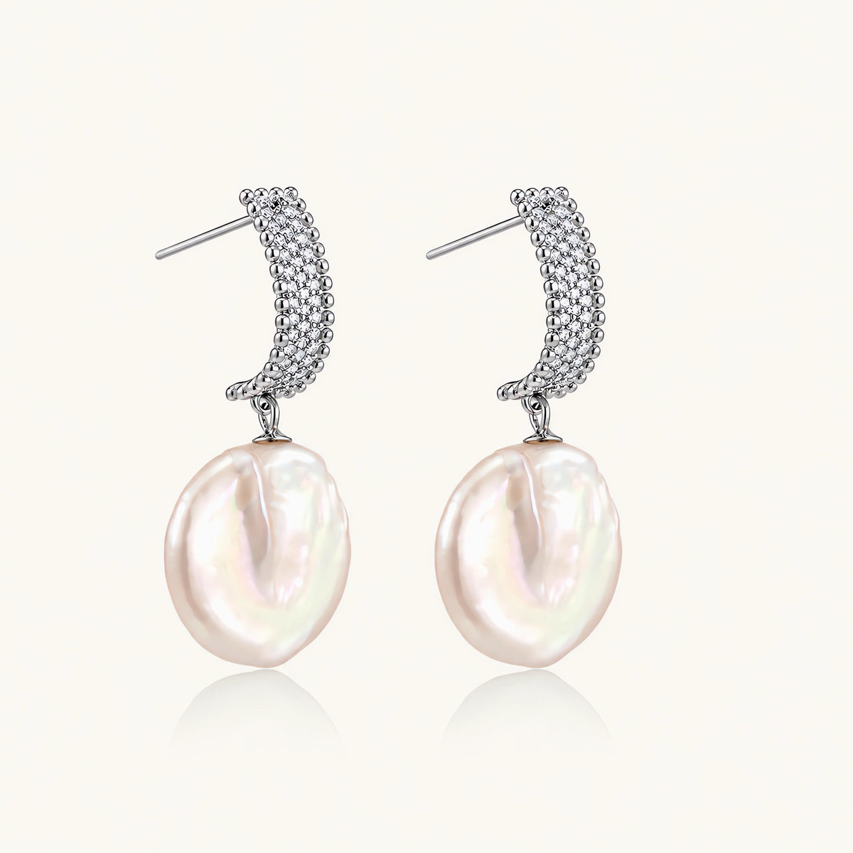 Rhodium-plated silver curved stud with pave stones and baroque pearl drop on white background