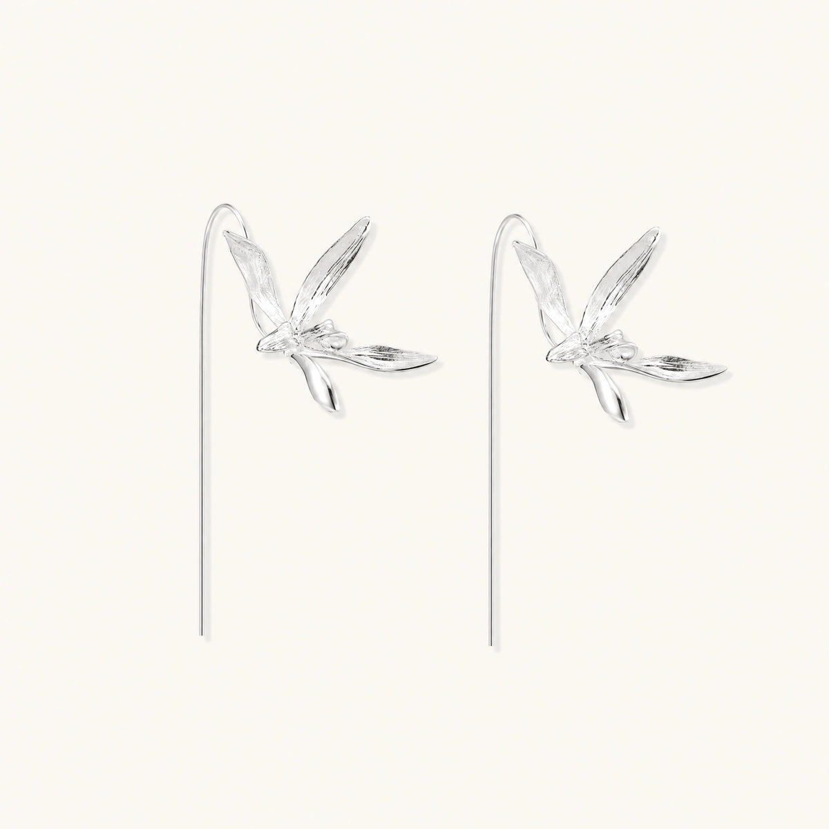 Delicate sterling silver dragonfly earrings with textured wings and curved threader hooks on white background