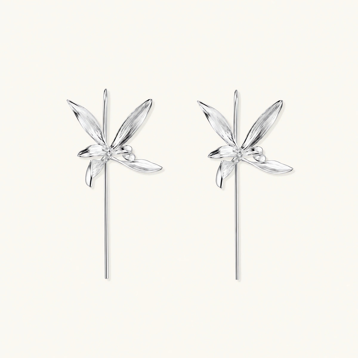 Delicate sterling silver dragonfly earrings with textured wings and curved threader hooks on white background