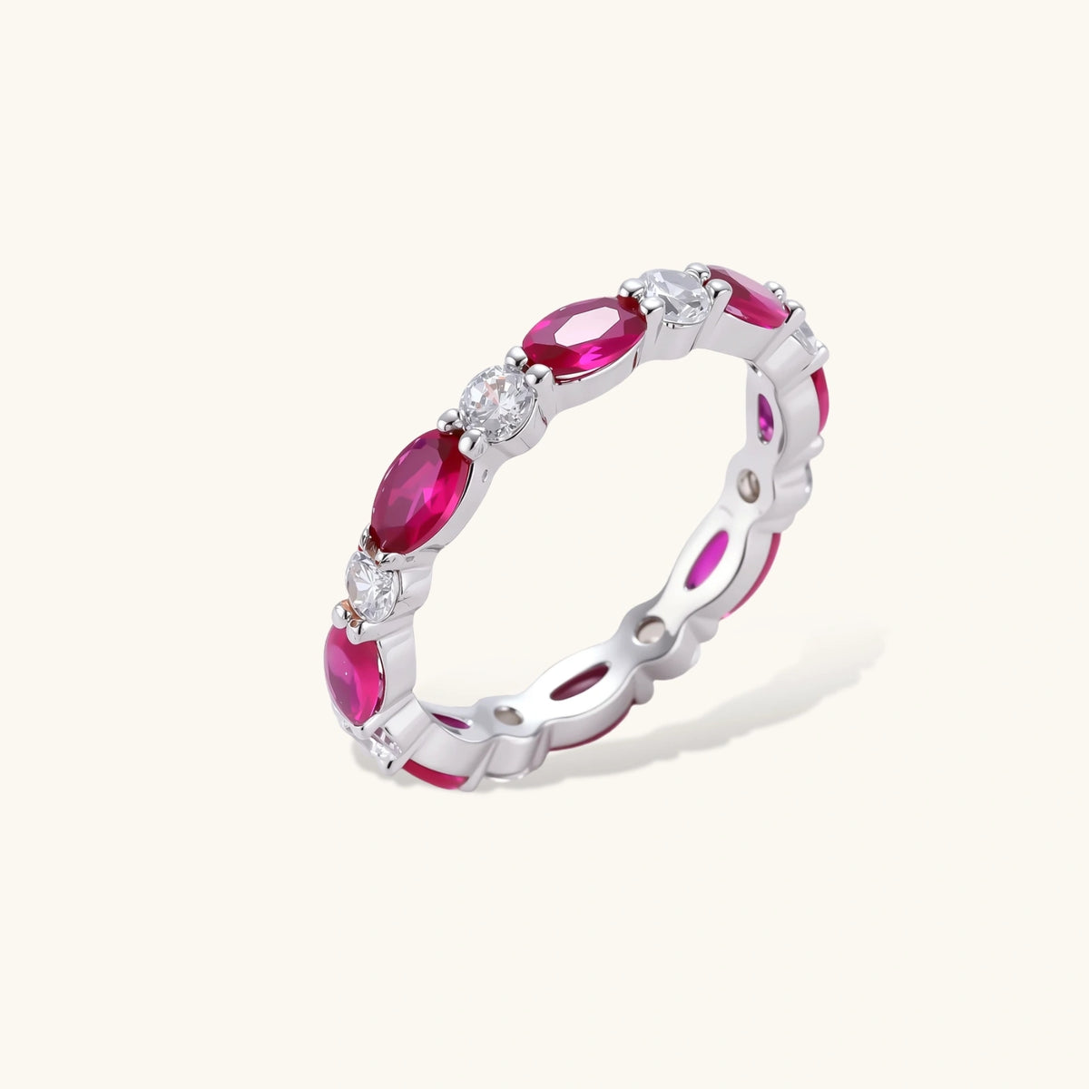 Platinum-plated eternity ring with alternating oval ruby and round clear stones in continuous band setting